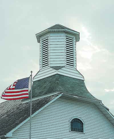 Flag flies next to Lowell Christian Church